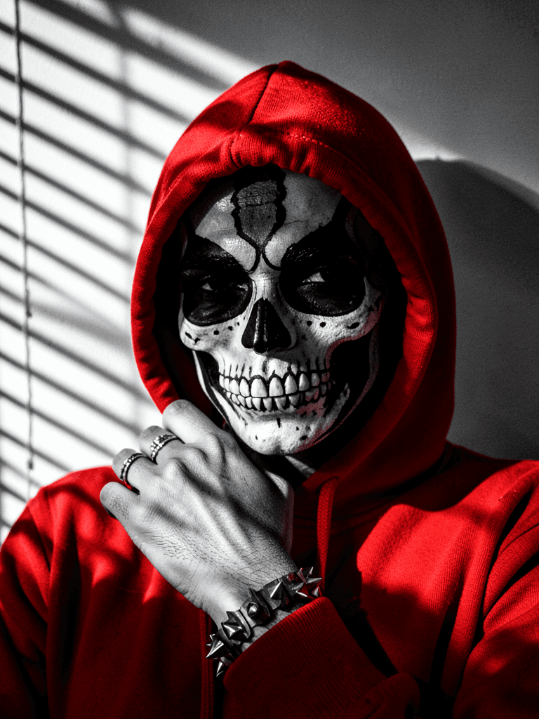 A close-up portrait of a person wearing a vibrant red hooded