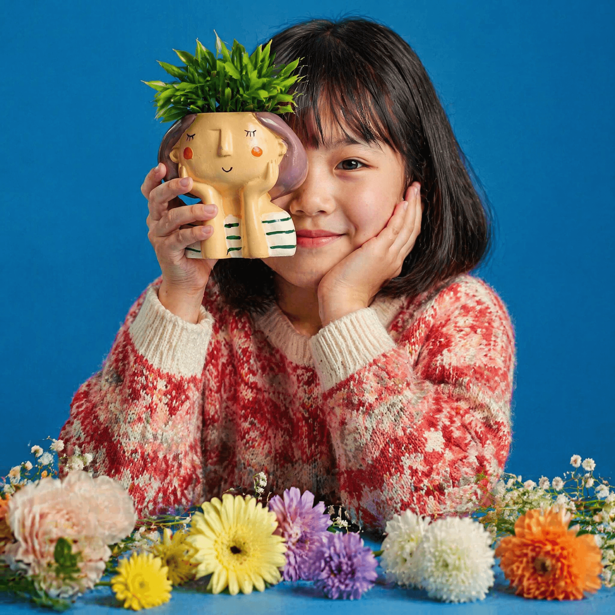 A cute young girl with short black hair and bangs smiling wh