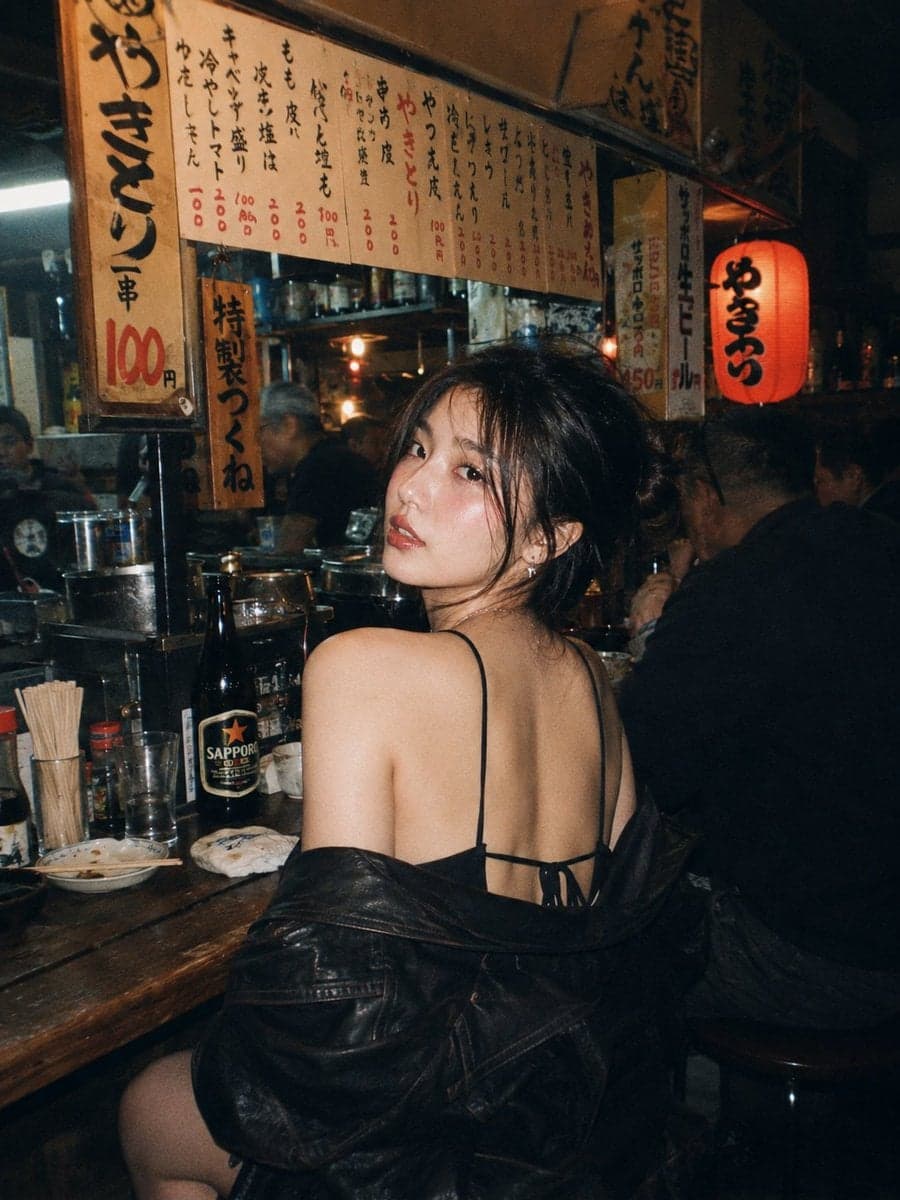 A beautiful young East Asian woman with long dark wavy hair 