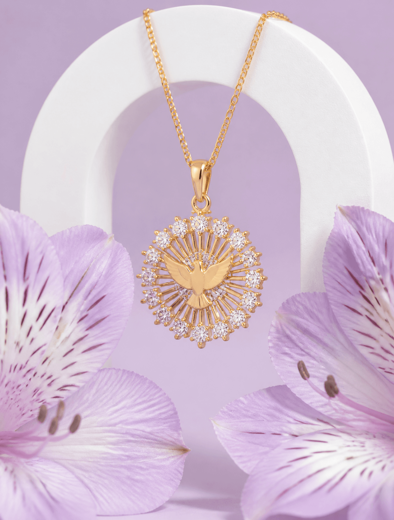 A delicate gold pendant featuring a central dove motif surro