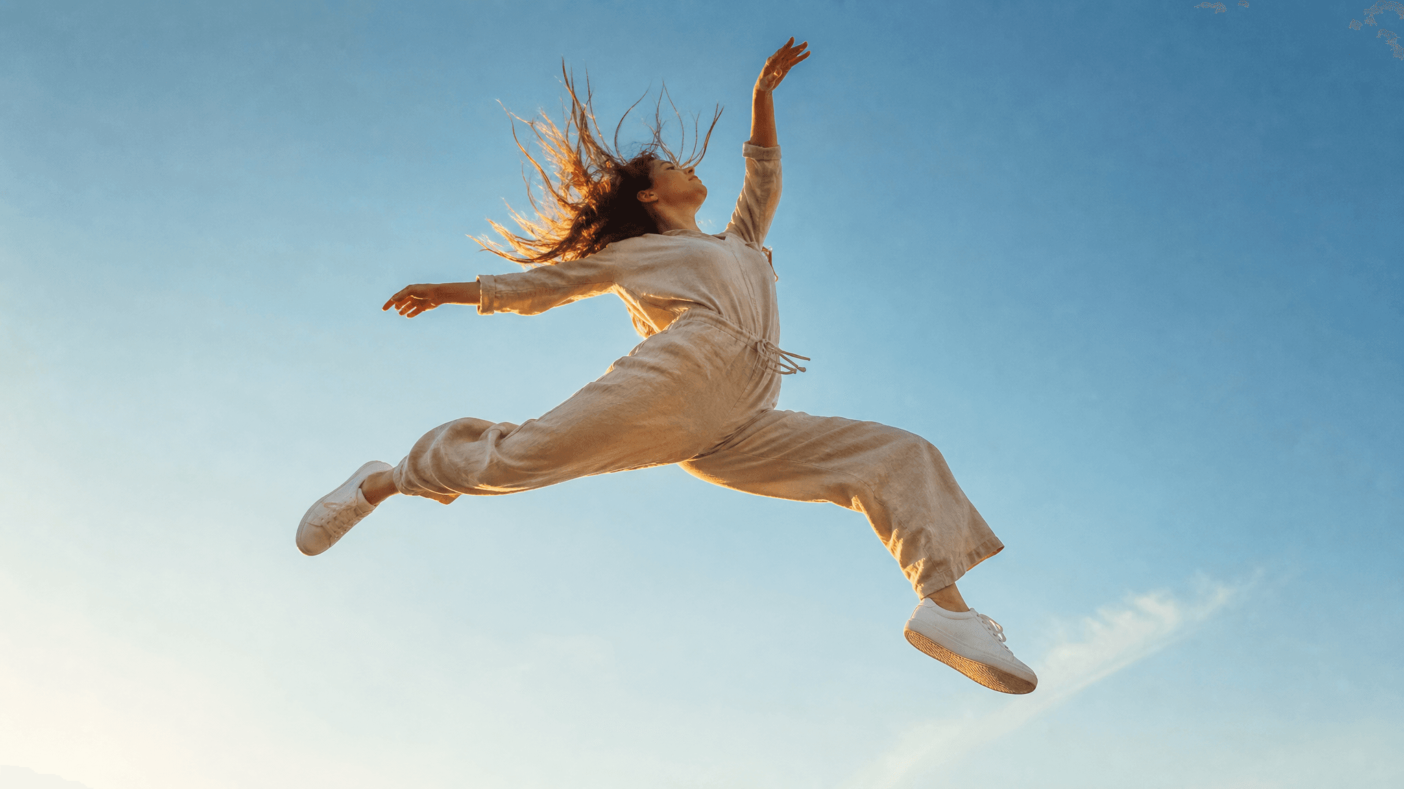 A young woman captured mid-air in a dynamic, gravity-defying