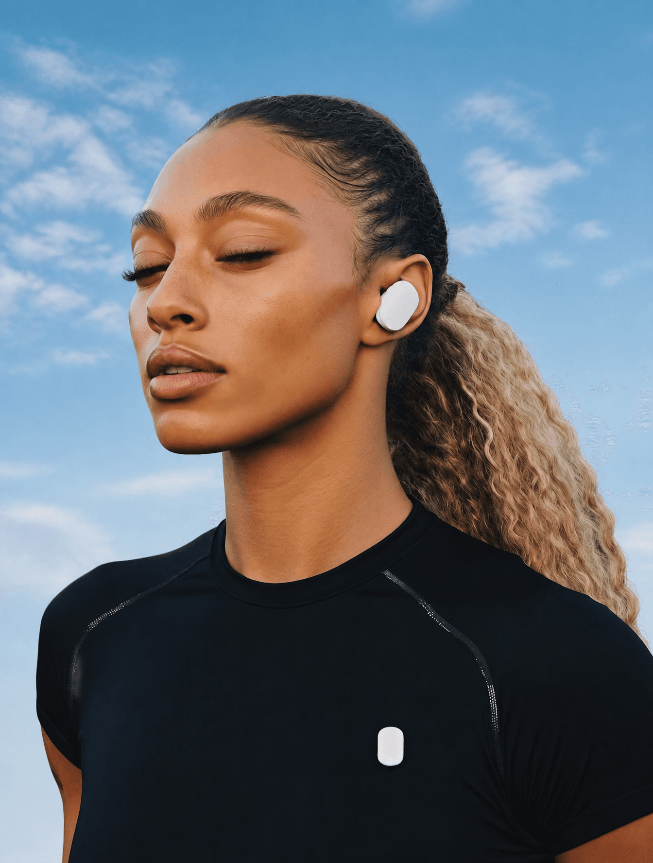 Confident woman with wireless earbuds in a blueish sky backg