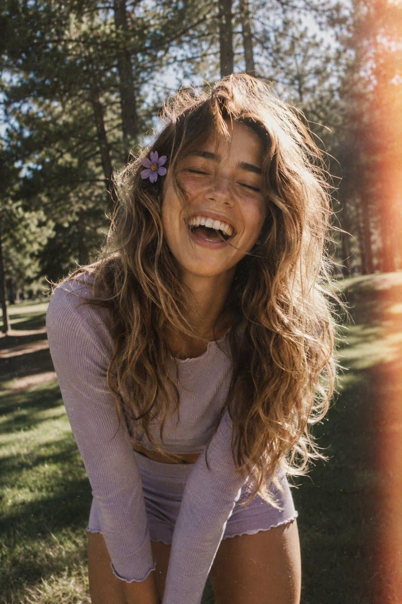 A candid, film-style portrait of a joyful young woman with l