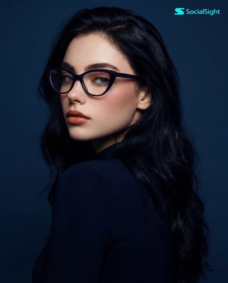 A young woman with long, dark hair and striking cat-eye glas