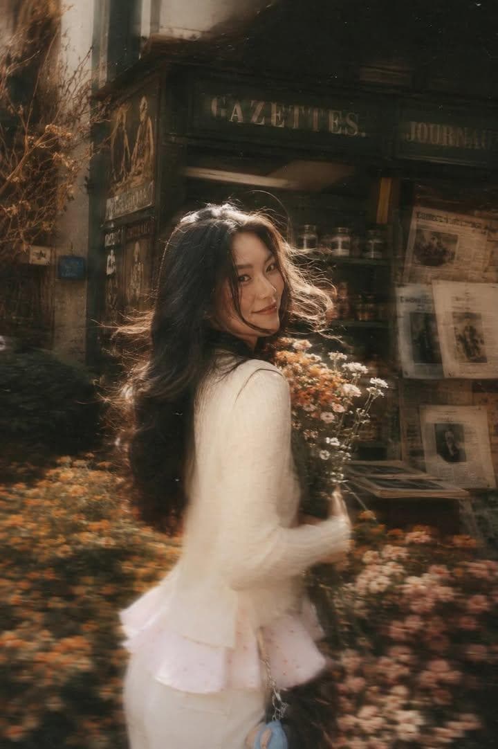 A beautiful young woman with long dark flowing hair holding