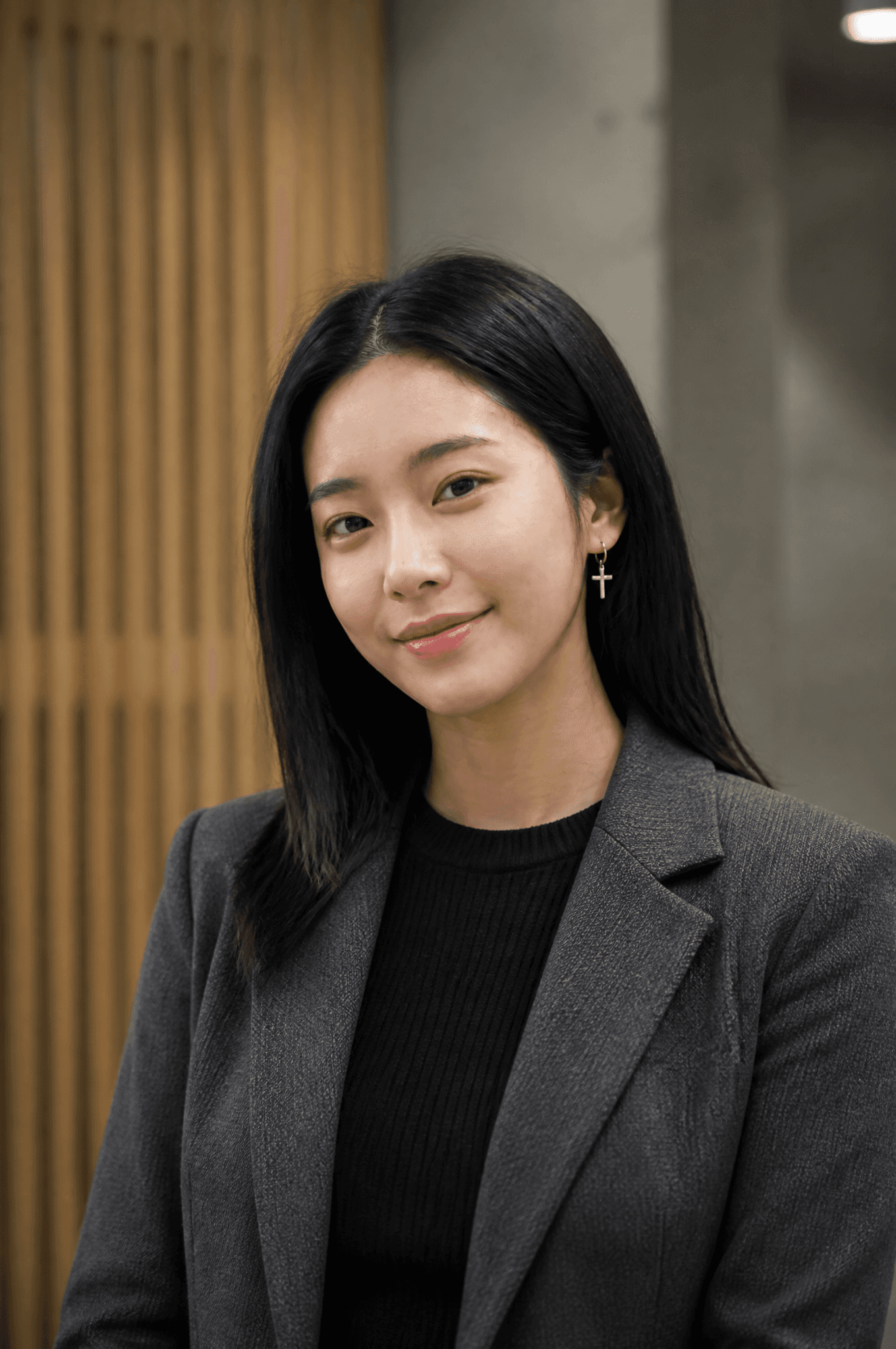 A young East Asian woman with shoulder-length dark hair stan