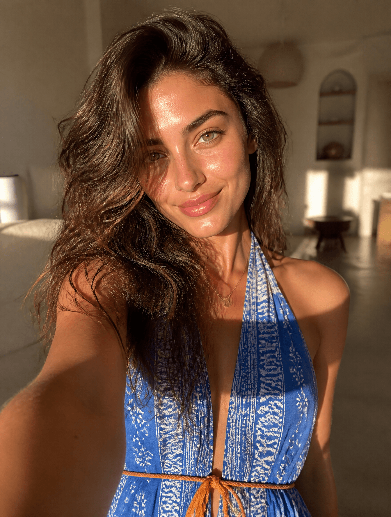 A young woman with voluminous, tousled brunette hair takes a
