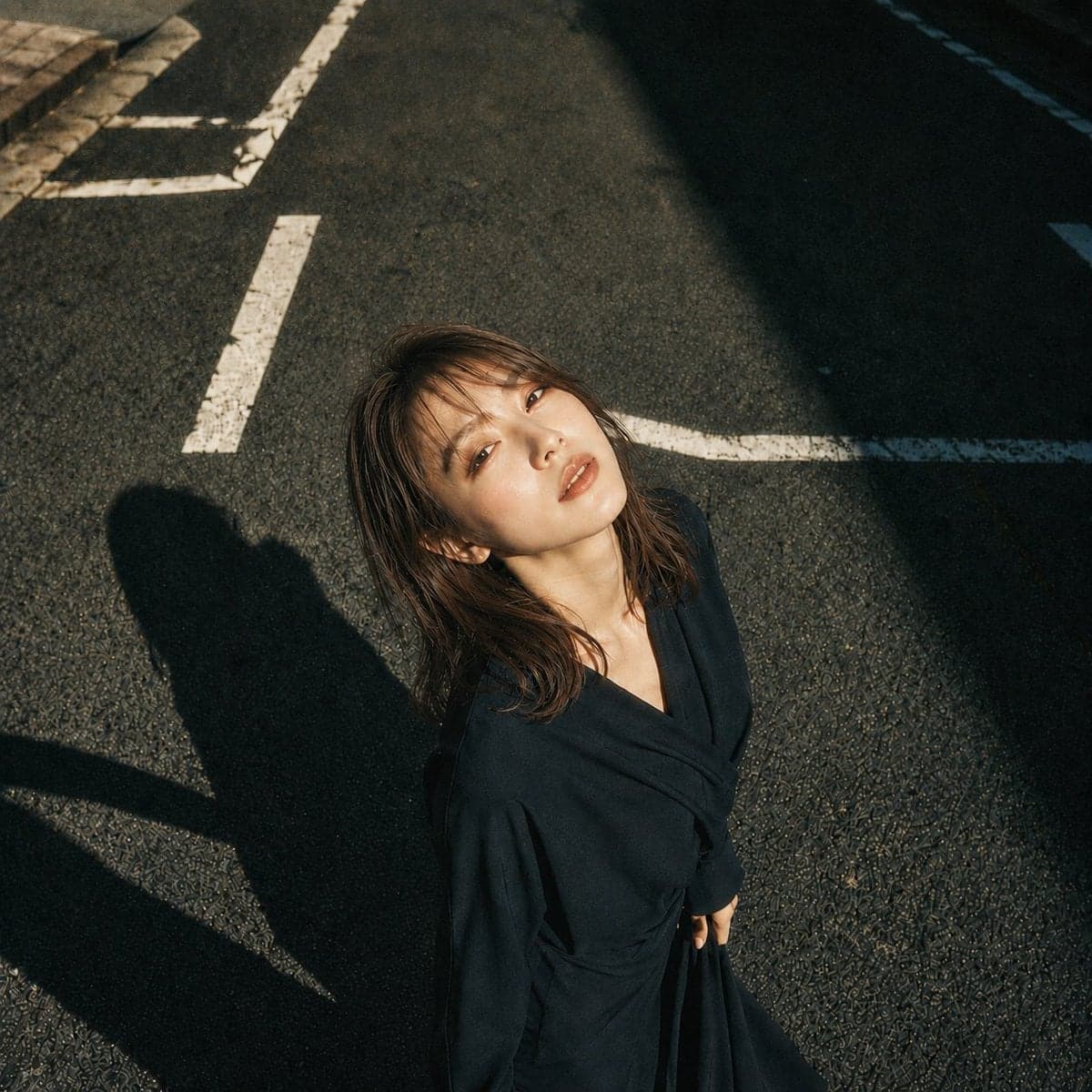 主題:白線と影
人物・表情:
20代女性。明るいアイボリーベージュ寄りの白肌に、ほんのりピンクの血色を含んだ自然な肌質