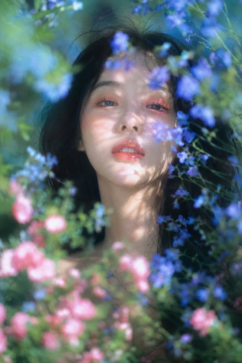 梦幻自然光花园人像,柔焦胶片质感,竖幅近距离肖像构图;年轻女性,muse般的面庞,黑色长发蓬松微乱,面部居中偏上作为主视