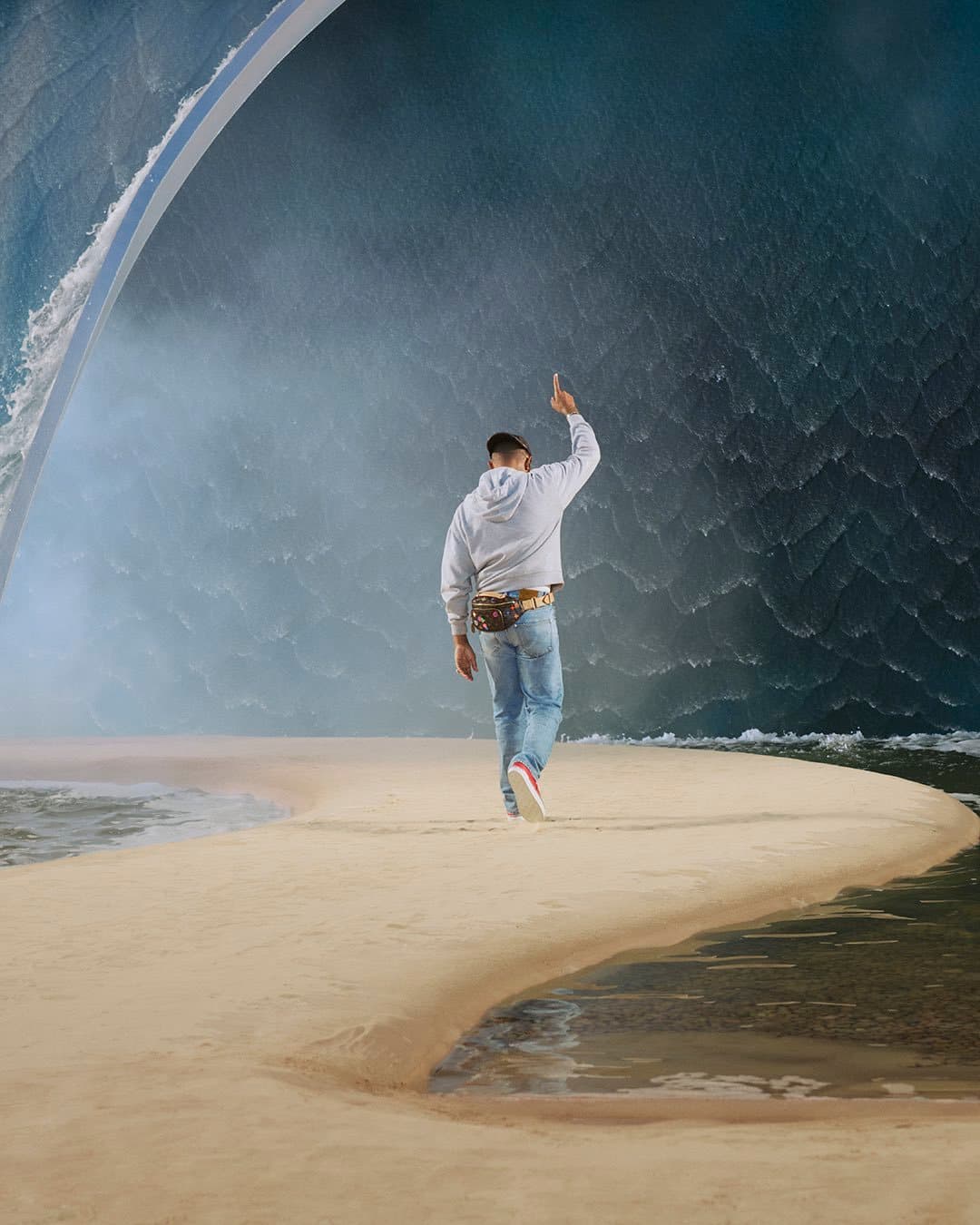 A man walking on a sandy path towards a massive artificial w