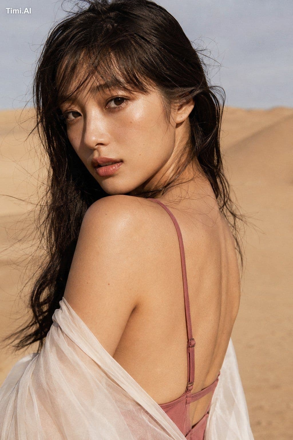 A young Japanese woman wears a dusty rose swimsuit with a cr