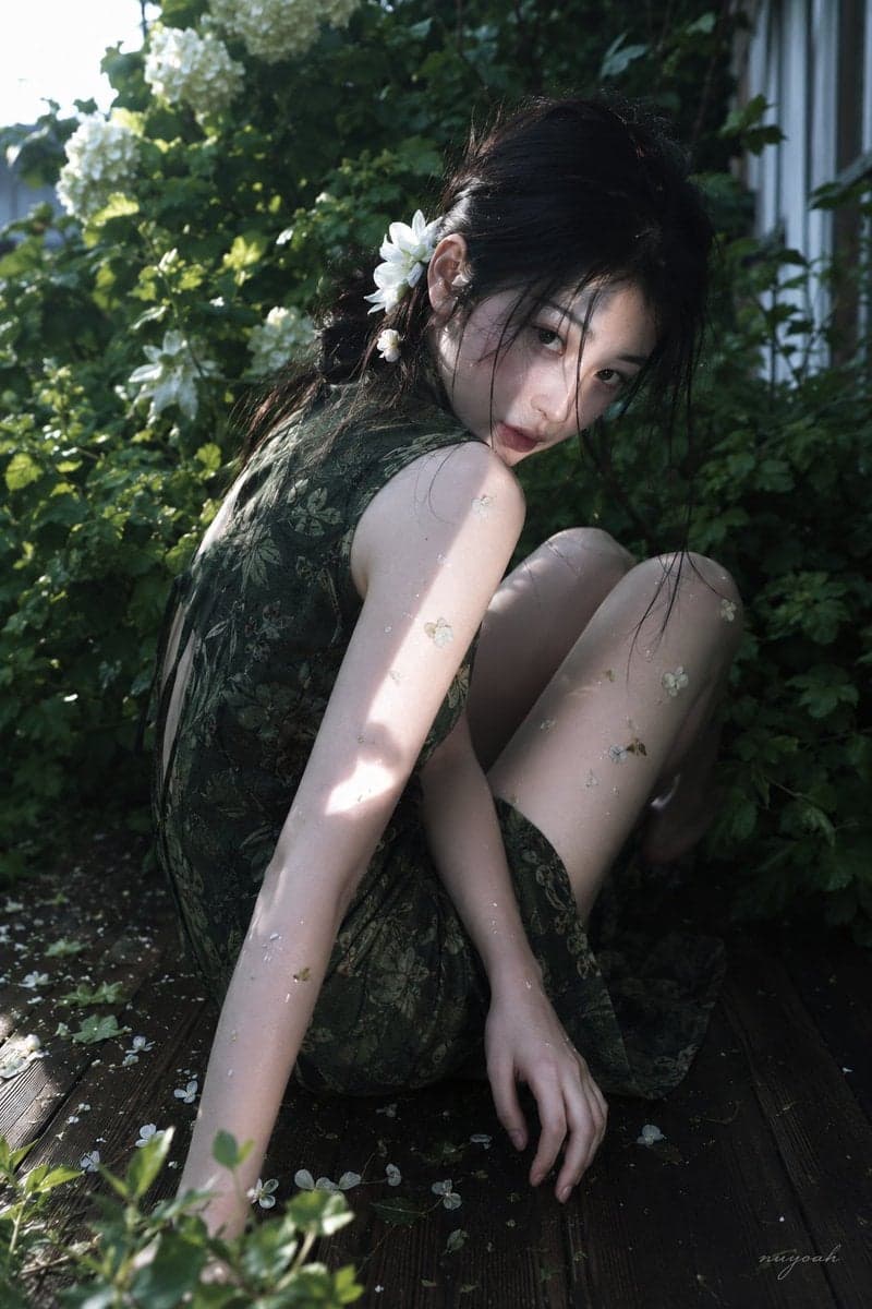 真人摄影,真实人物,户外花园唯美人像写真,低饱和冷绿调与斑驳自然光,轻微胶片柔焦和电影感。竖幅近中景,略高机位俯拍,人物